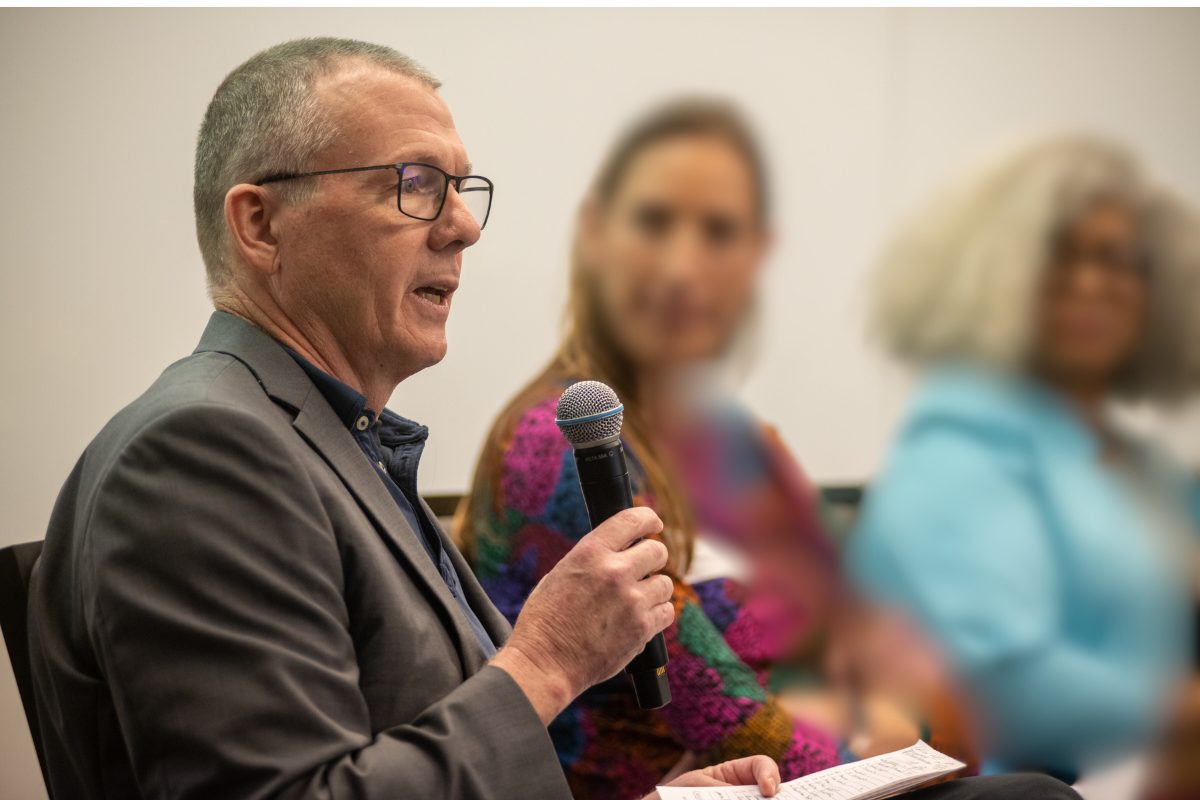 New director Matt Kammer-Kerwick speaks into microphone at Health Equity conference.