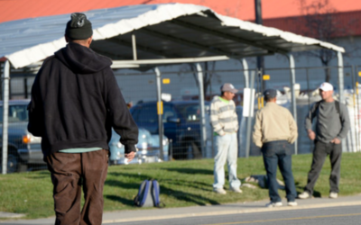 Day laborers waiting for jobs on a sidewalk.