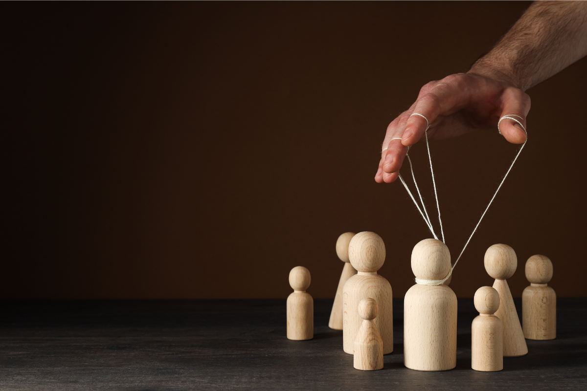 A puppeteer controls the moves of a person - demonstrating exploitation.