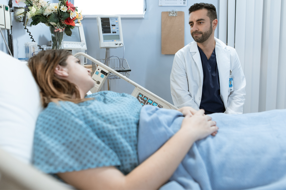 Doctor greets patient in hospital bed